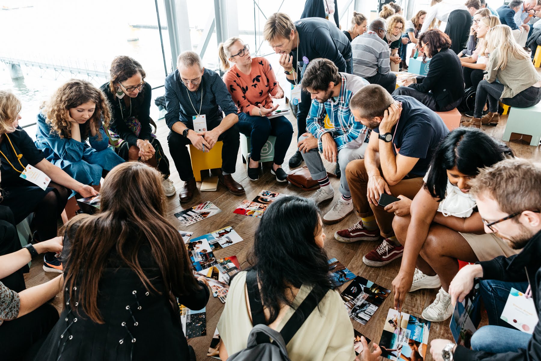 Groups of people from different age and backgrounds gathering in circles to discuss and engage.